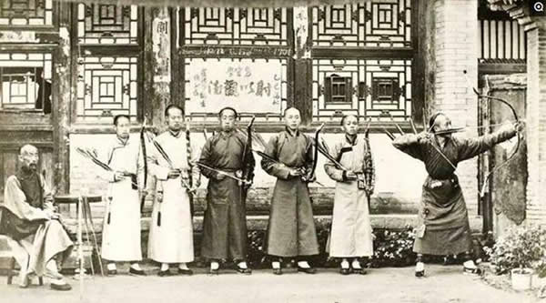 晚清真实图为几个男子正在练习射箭,第一个男子撅起屁股,上半身向前倾,准备射箭。这个姿势是为了避免弦打到衣服,还有就是在骑马时射箭就是这个姿势。