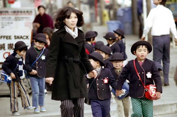 在老师带领下通过交通路口的学童;日本东京,1972年。