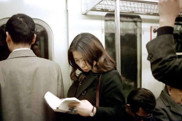 地铁车厢内看书的姑娘;日本东京,1972年。