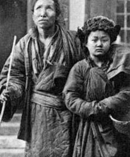 图为清朝时期行乞的父女,画面中我们可以看到父亲眼睛失明了,左手搭在女儿肩上,右手拿着一根木棍。