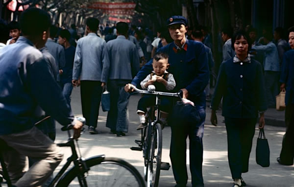 北京王府井地区,父亲骑着自行车载儿子出去逛街。看着这个画面,让人怀念起小的时候。